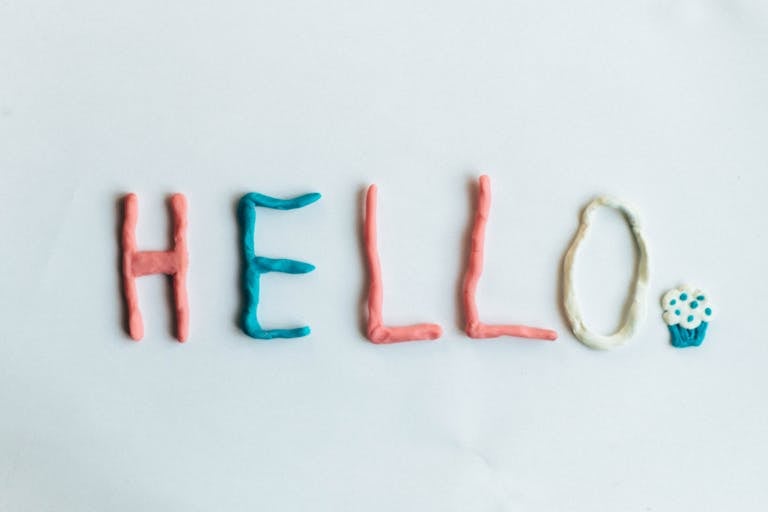 Creative hello greeting spelled out with colorful clay on a white background.