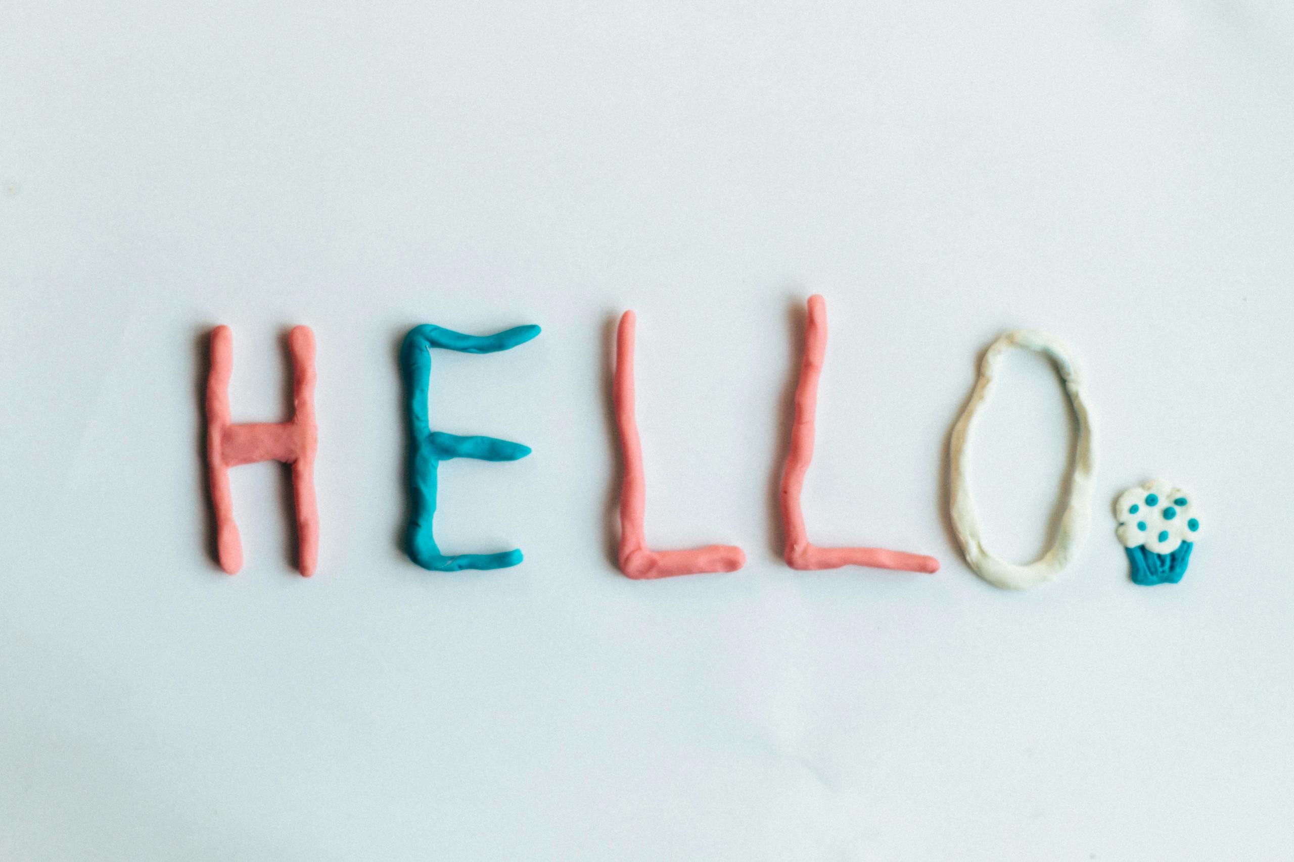 Creative hello greeting spelled out with colorful clay on a white background.